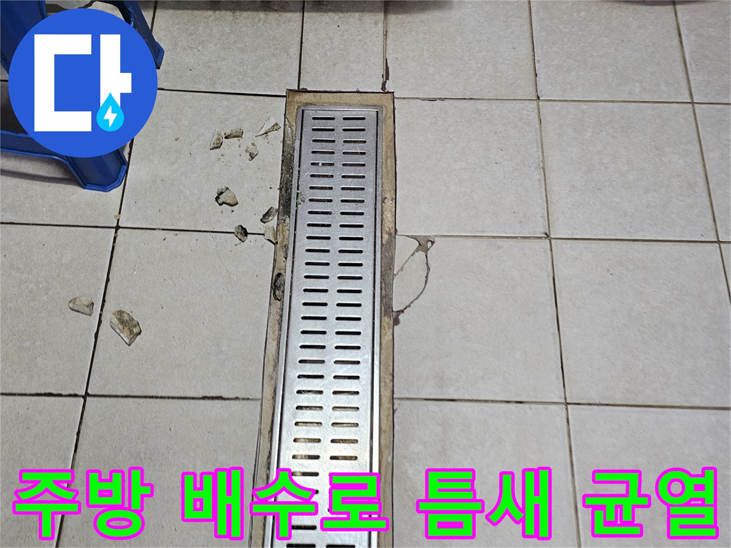 금속 재질의 배수 트렌치 덮개와 파손된 타일 경계면