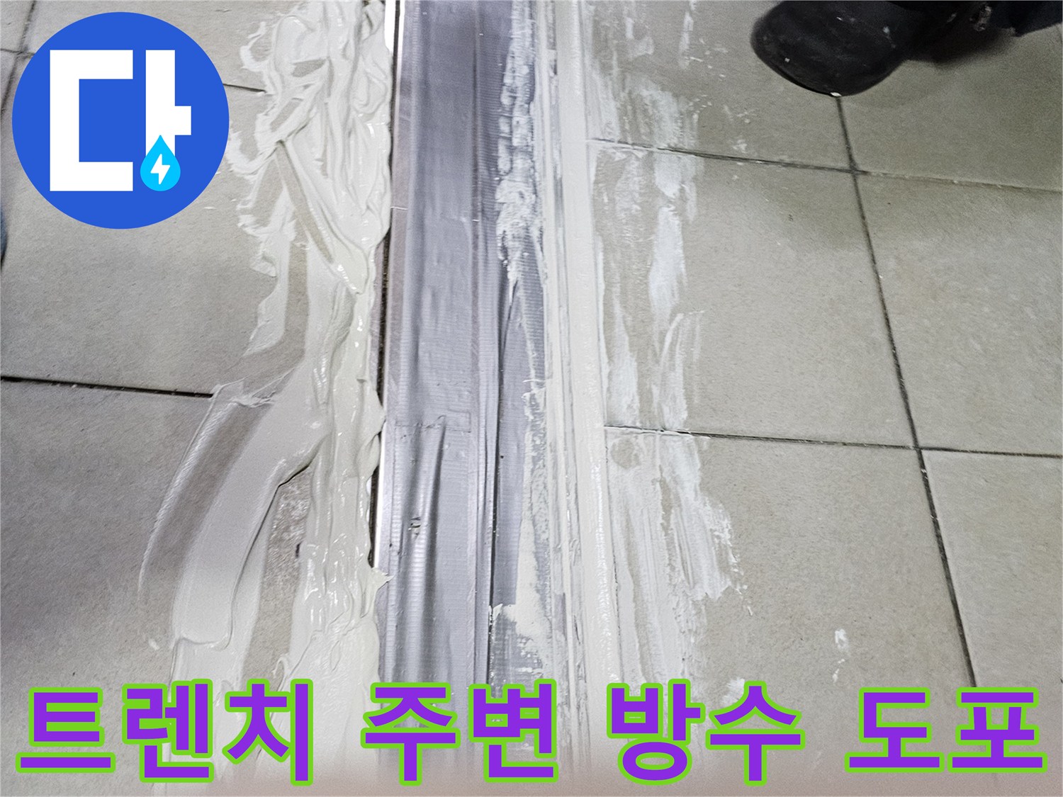 벌어진 타일 틈새와 트렌치 경계면에 방수제를 두껍게 바르고 있습니다.