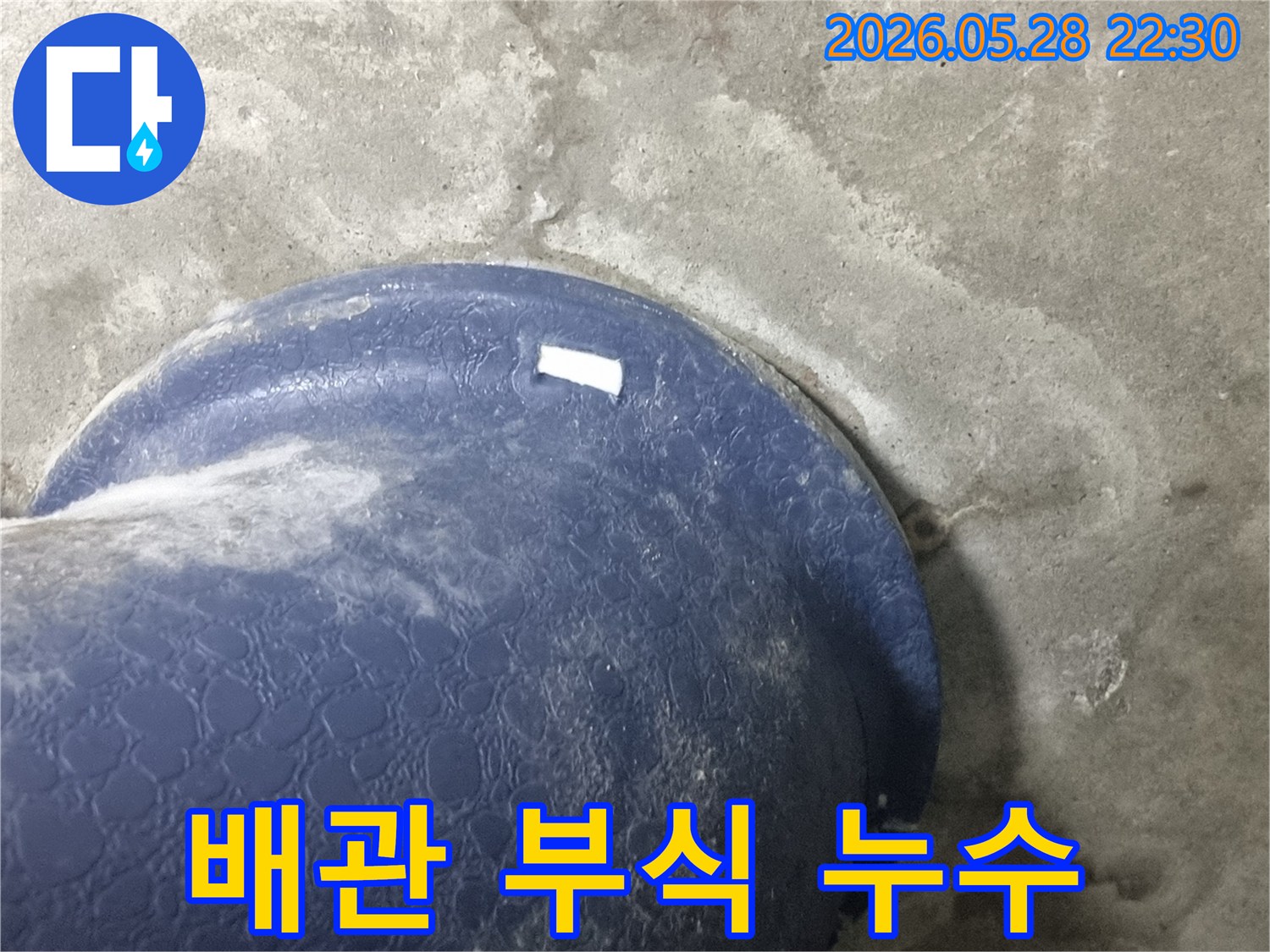 콘크리트 바닥의-파란색 배관-주변으로-물이-새어-나와-젖은-모습을-보여주는-배관-부식-의심-현장-사진