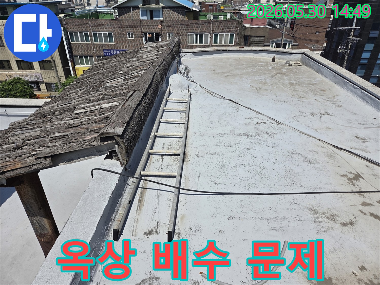 옥상 배수 문제와 누수의 연관성을-파악하기 위해 옥상 바닥을-점검하는 현장 모습