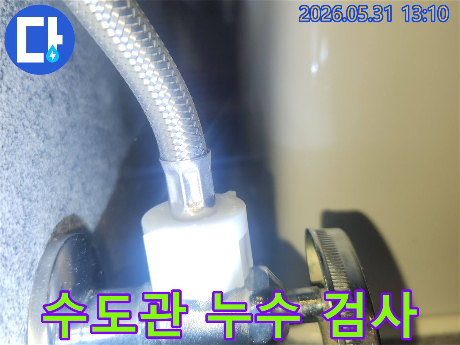 수도 밸브와 연결된 호스에서-누수가 없는지-정밀하게 확인하는 순간을 담았습니다.