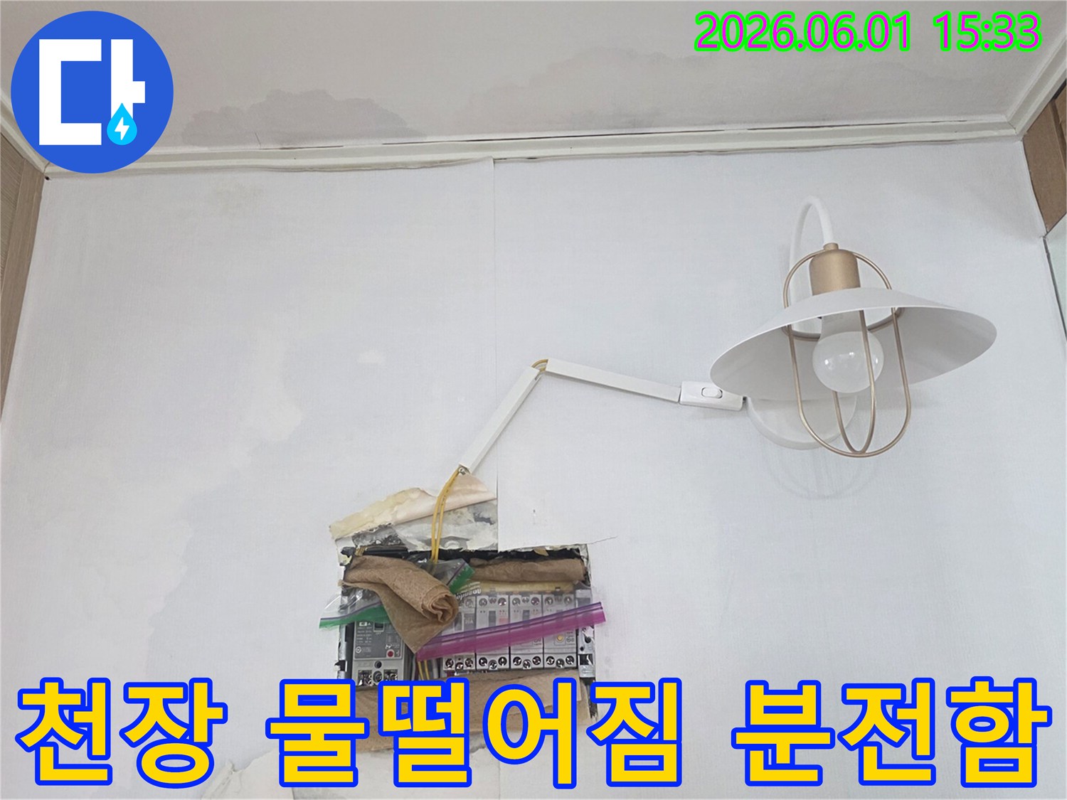 천장에서 물이 떨어져 분전함 주변이 젖어있는 모습으로-전기 합선 위험이 있어 즉각적인 조치가 필요한 상황입니다