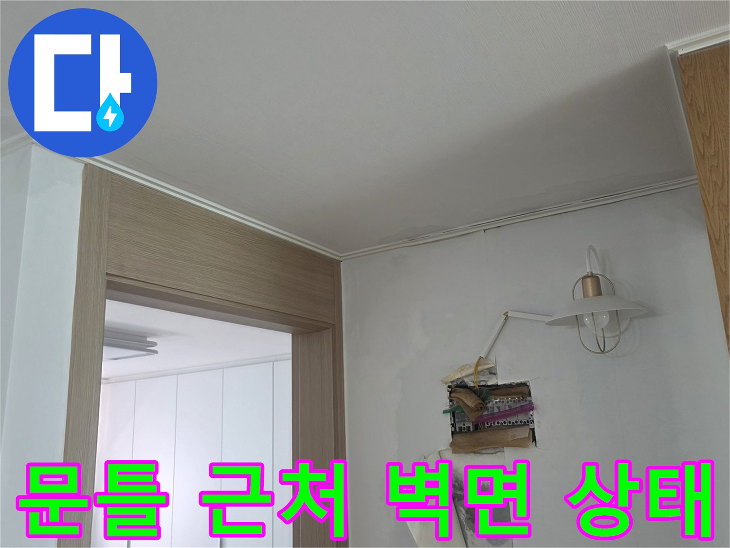하얀색 벽지와 문틀 사이의 습윤한 상태를 보여주는 사진입니다.