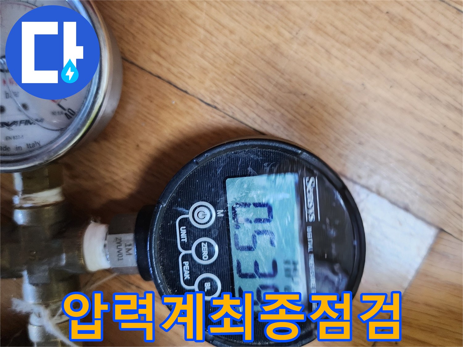 아파트 누수 수리 후-압력계를 사용하여-배관의 최종 점검을-완료하는 장면