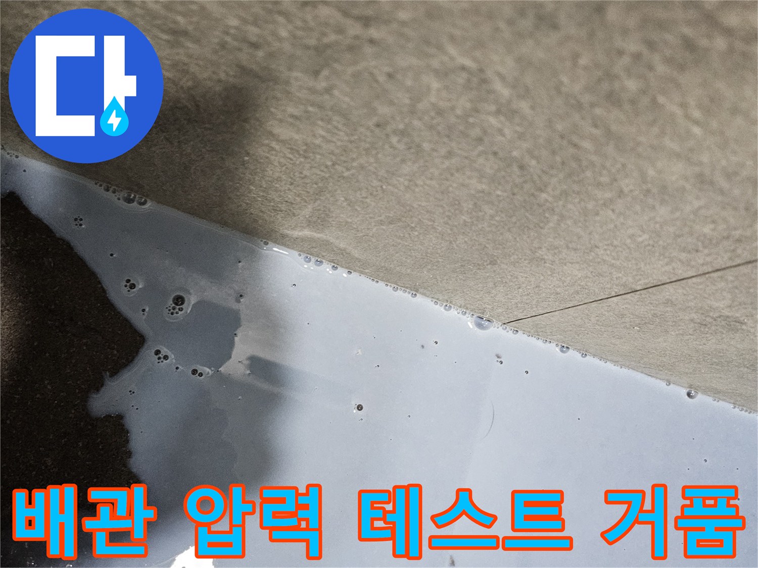 하수 배관의 기밀성을 확인하기 위해 비눗물로 반응을 관찰하는 현장 사진