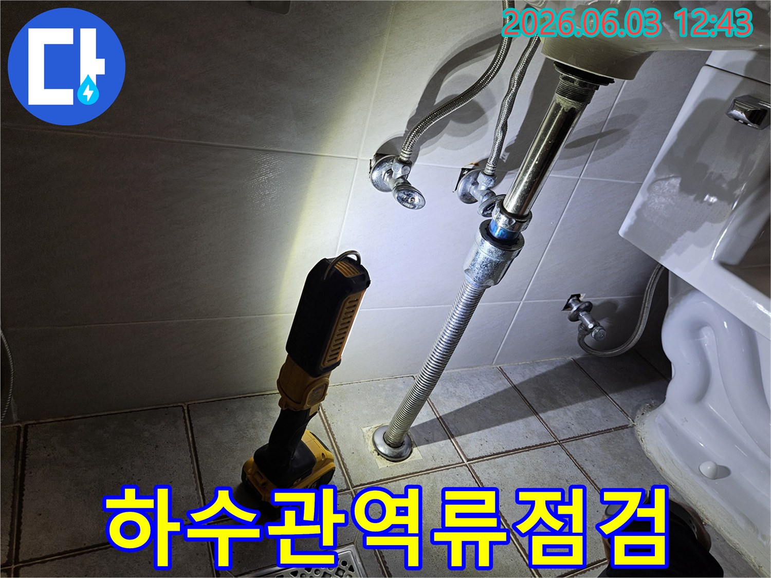 화장실 배수관 주변을-정밀하게 점검하기 위해-사용된 강력한 조명이-누수 흔적을 드러내고 있습니다.