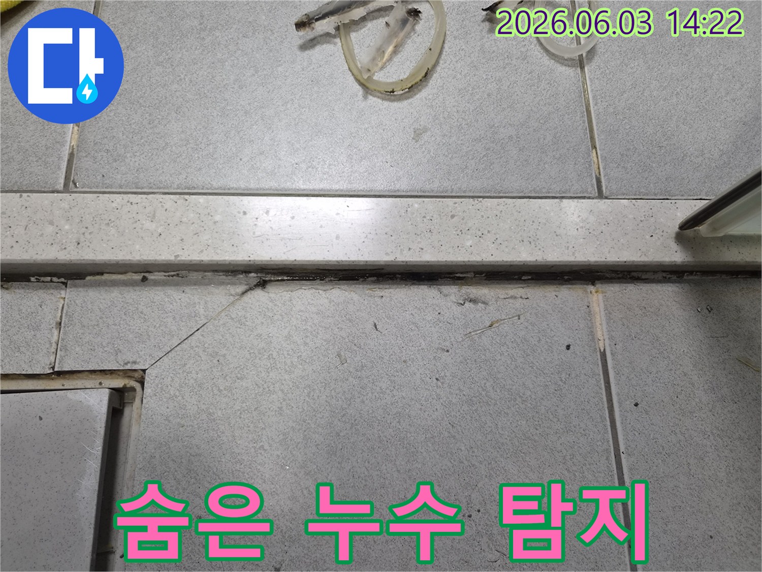 바닥 마감재 아래-숨겨진 누수 지점을-찾아내기 위해-틈새를 면밀히 살피는-탐지 작업 현장입니다