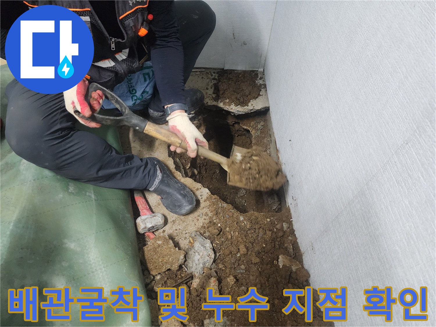 기술자가 삽으로 흙을 파내어 노출된 배관 부위를 점검하는 모습