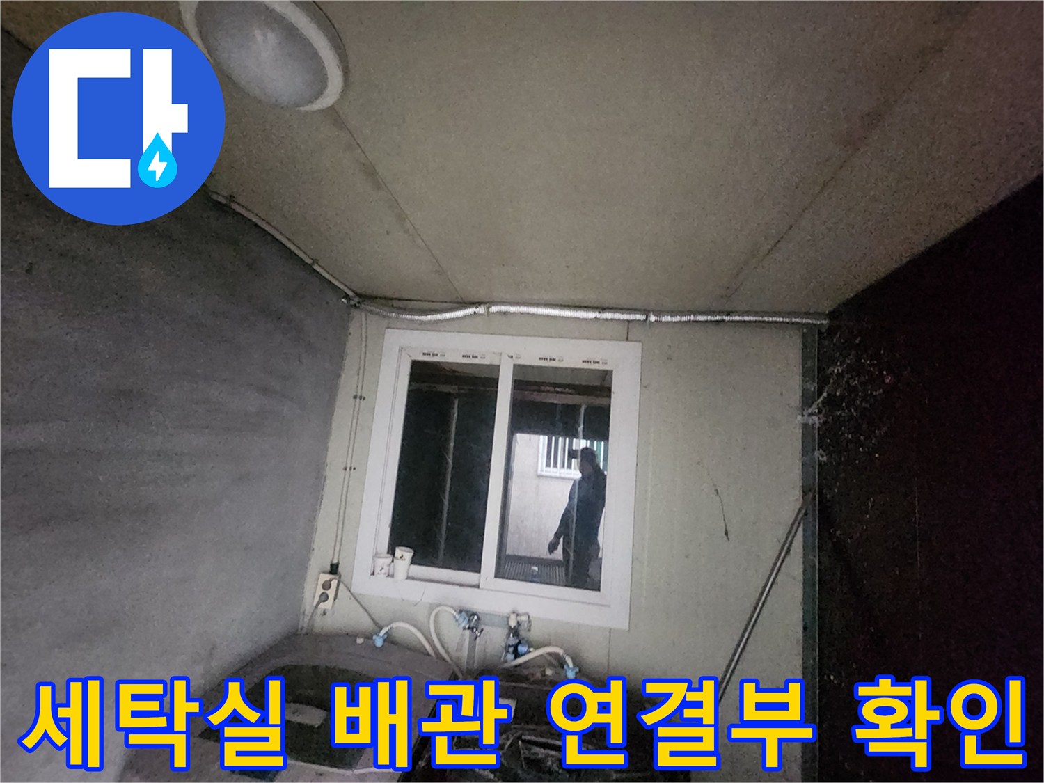 세탁실 내부에 노출된 수도 배관과 세탁기 연결 부위를 점검하는 모습