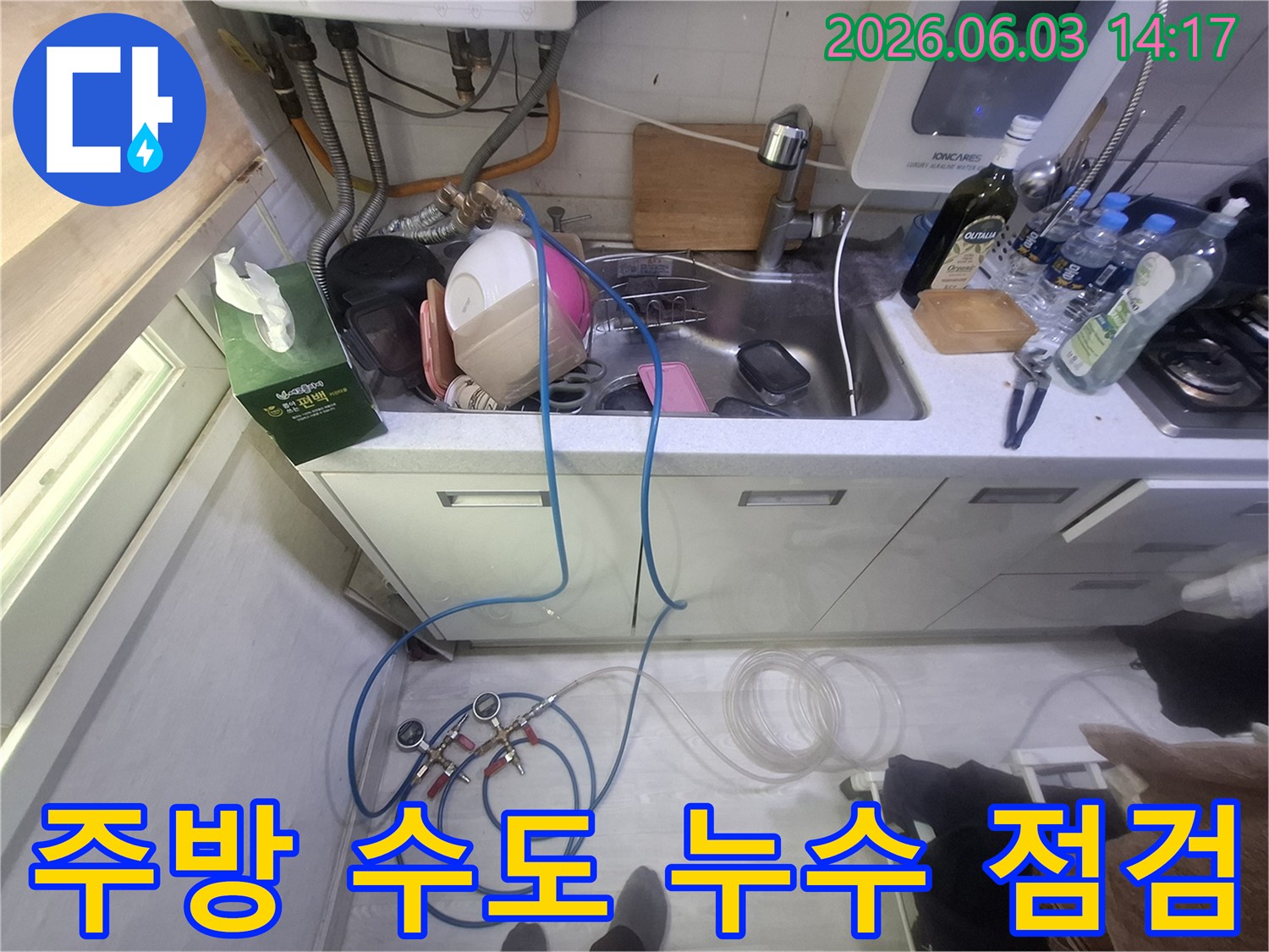 영등포 주방 싱크대 아래-수도 배관에서 발생한 누수를-정확히 찾아내기 위해-압력 테스트 장비를 연결하여-진단하는 현장