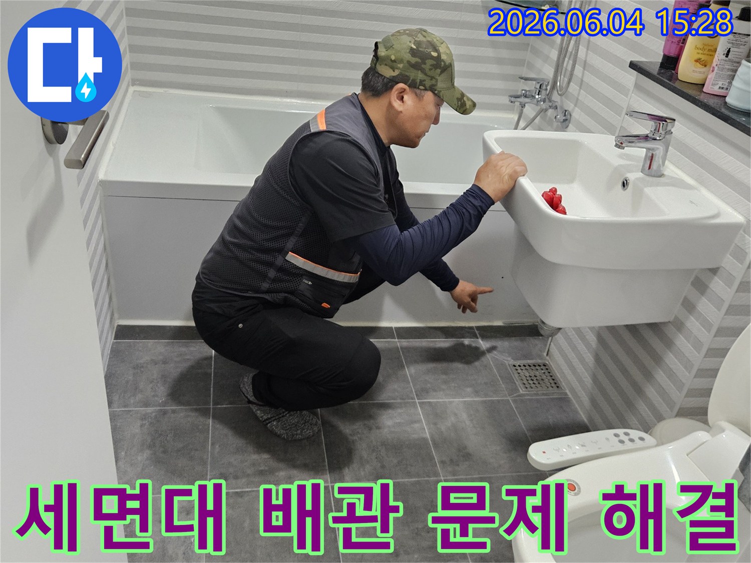 전문 엔지니어가-목동 월드아파트 욕실의-세면대 하부 배관에서-발생한 누수 문제를-정확히 진단하고-해결 방안을 모색하고 있습니다