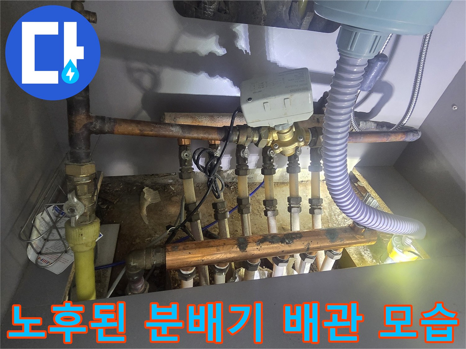 싱크대 하부장 내부의 부식된 금속 배관과 연결 부위 상태