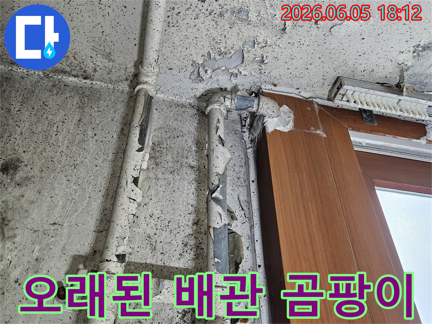 오래된 배관 주변 벽면에서 물이 새어-나와 페인트가 벗겨지고-검은 곰팡이가 피어난 모습입니다