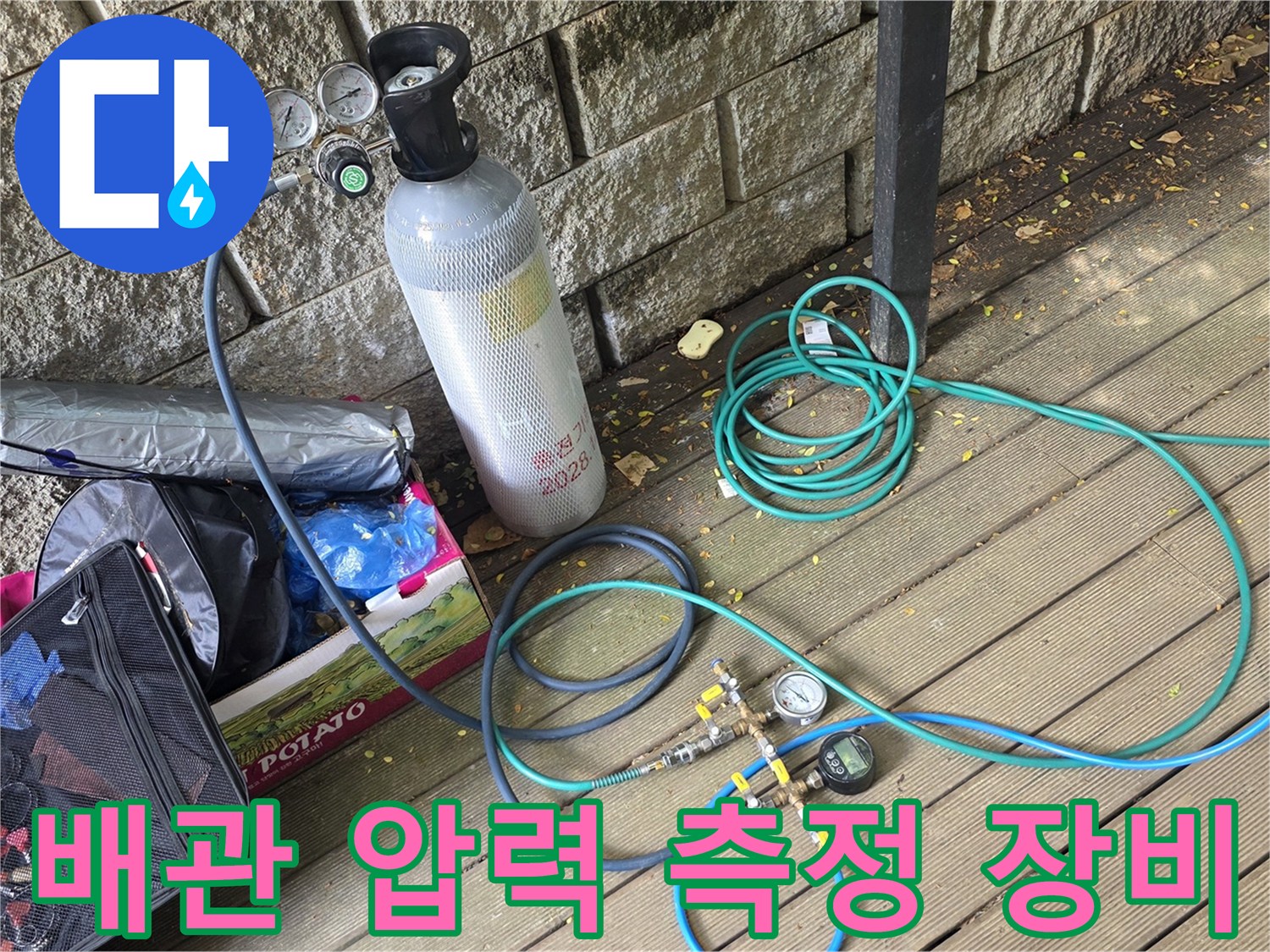 현장 바닥에 배치된-가스 주입용 실린더와 연결 호스 뭉치
