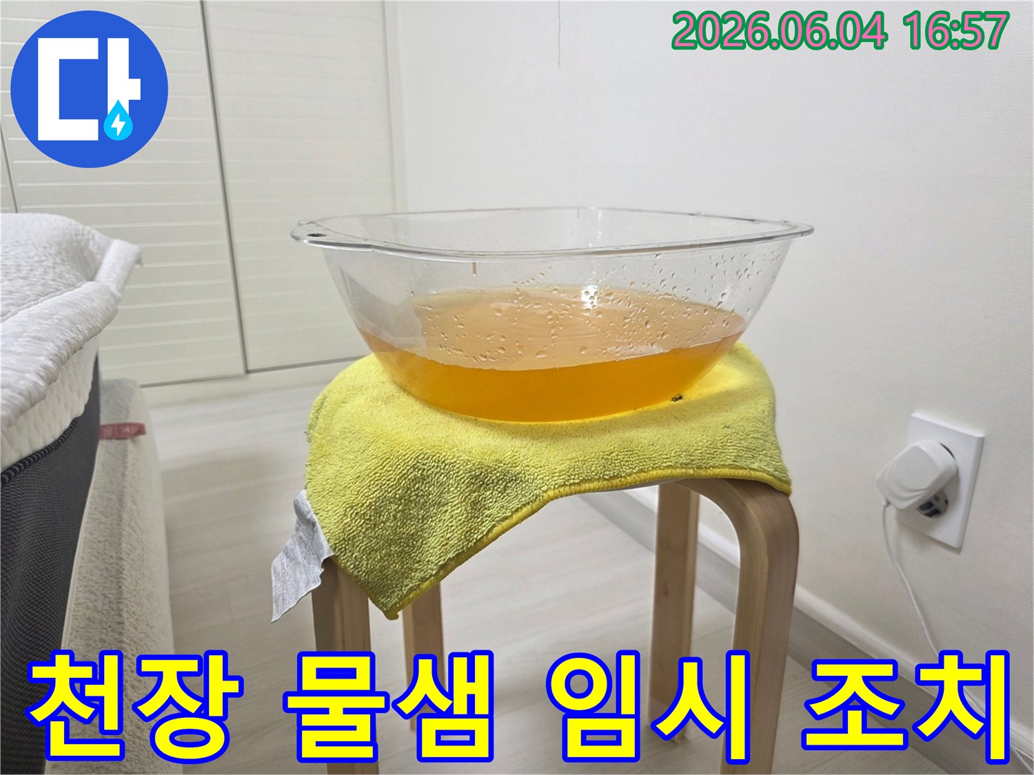 누수로 인해 천장에서 물이 떨어지는 상황에서-바닥과 가구의 손상을 방지하기 위해-설치된 임시 물받이의 모습