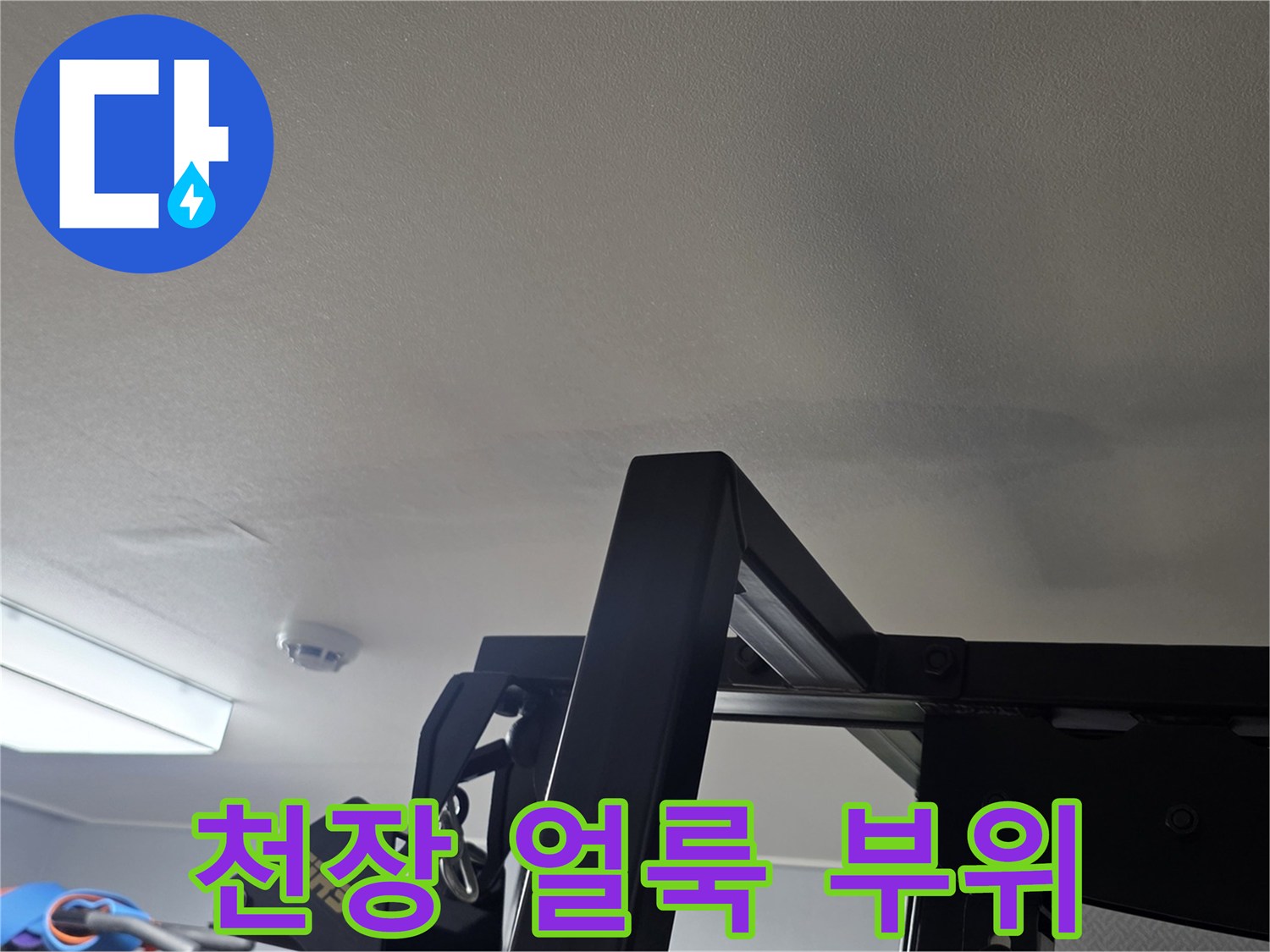거실 천장 벽지의 누수 흔적과 변색된 부분