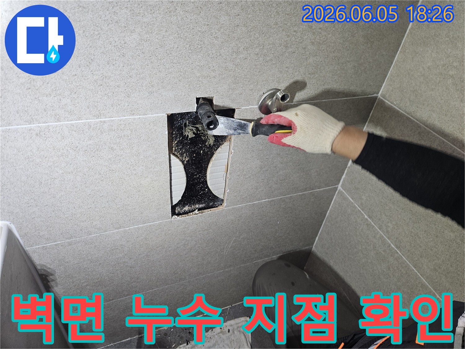타일 안쪽에서 발견된-누수 흔적과-곰팡이를 제거하며-배관 상태를-면밀히 점검하는-전문가의 손길이-엿보이는 사진입니다.