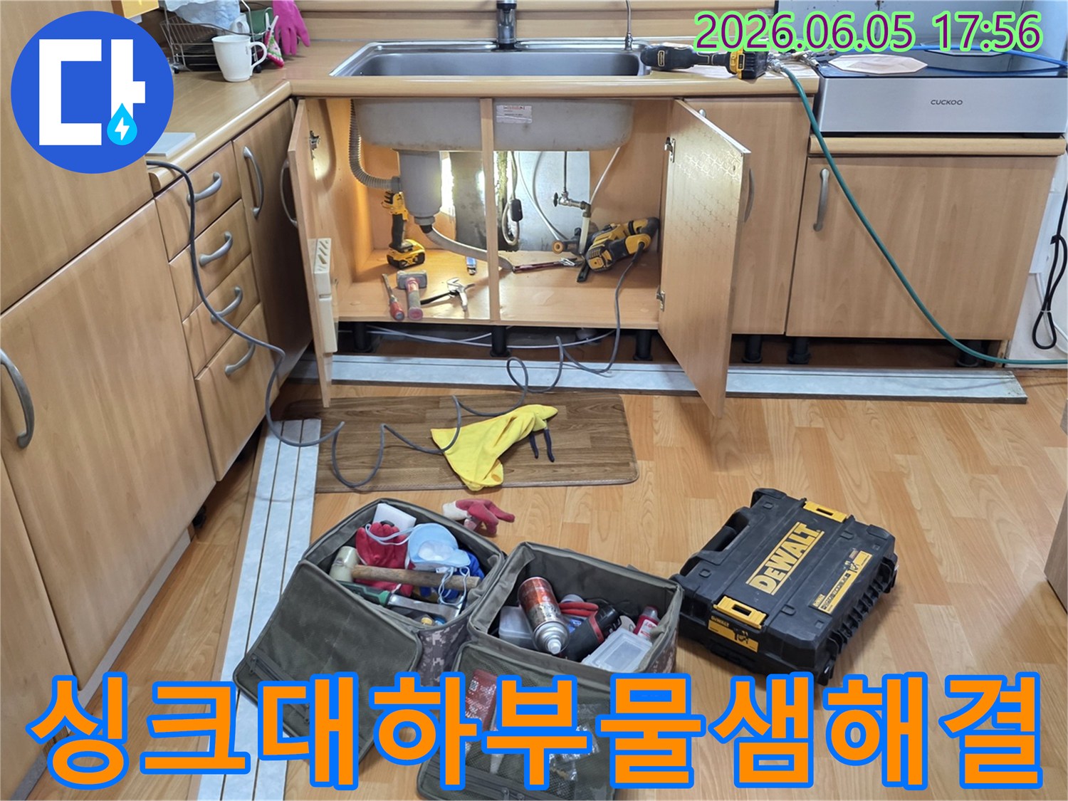 싱크대 하부장에서-누수 문제를 해결하기 위해-다양한 공구들이-사용될 준비를 하고 있습니다.