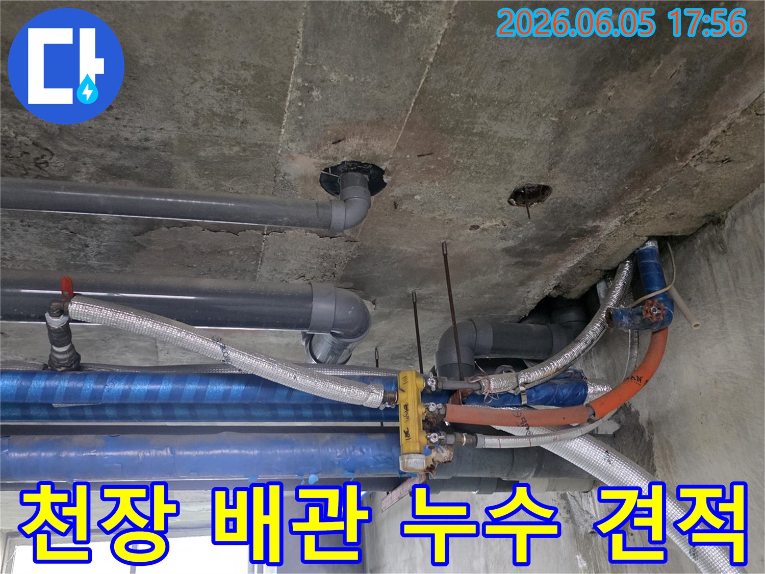 콘크리트-천장-아래-설치된-다양한-배관들의-복잡한-모습-누수-탐지-전문가가-현장을-면밀히-조사하고-있습니다