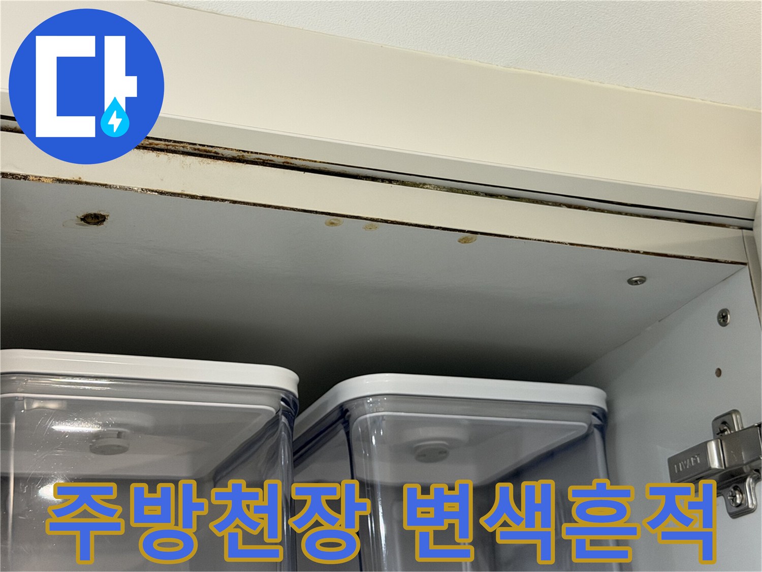 싱크대 상단 천장 판재의 젖은 듯한 변색 부위를 클로즈업한 사진입니다.
