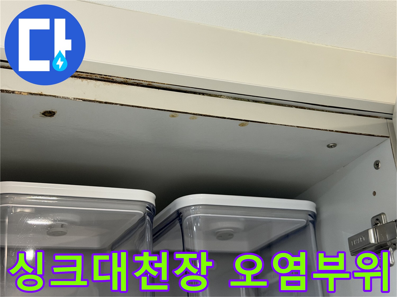싱크대 상단 천장 판재의 젖은 부위와 변색된 경계면을 촬영한 사진입니다.