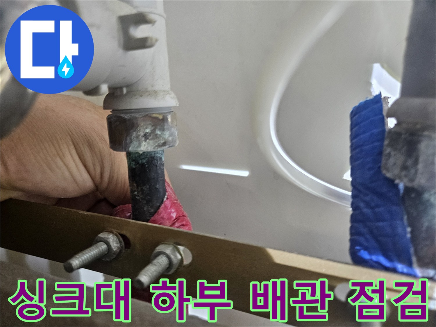 싱크대-하부장-내부-배관-연결-부위-누수-점검-중인-모습