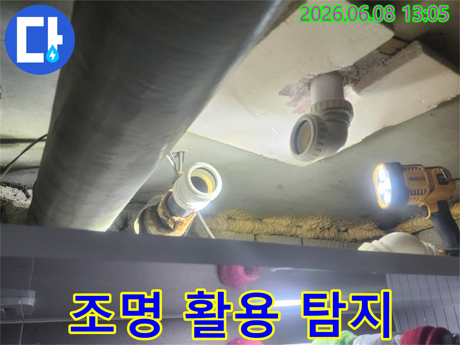 강력한-작업등을-사용하여-어두운-천장-속-배관을-밝히고-누수-지점을-찾아내는-모습
