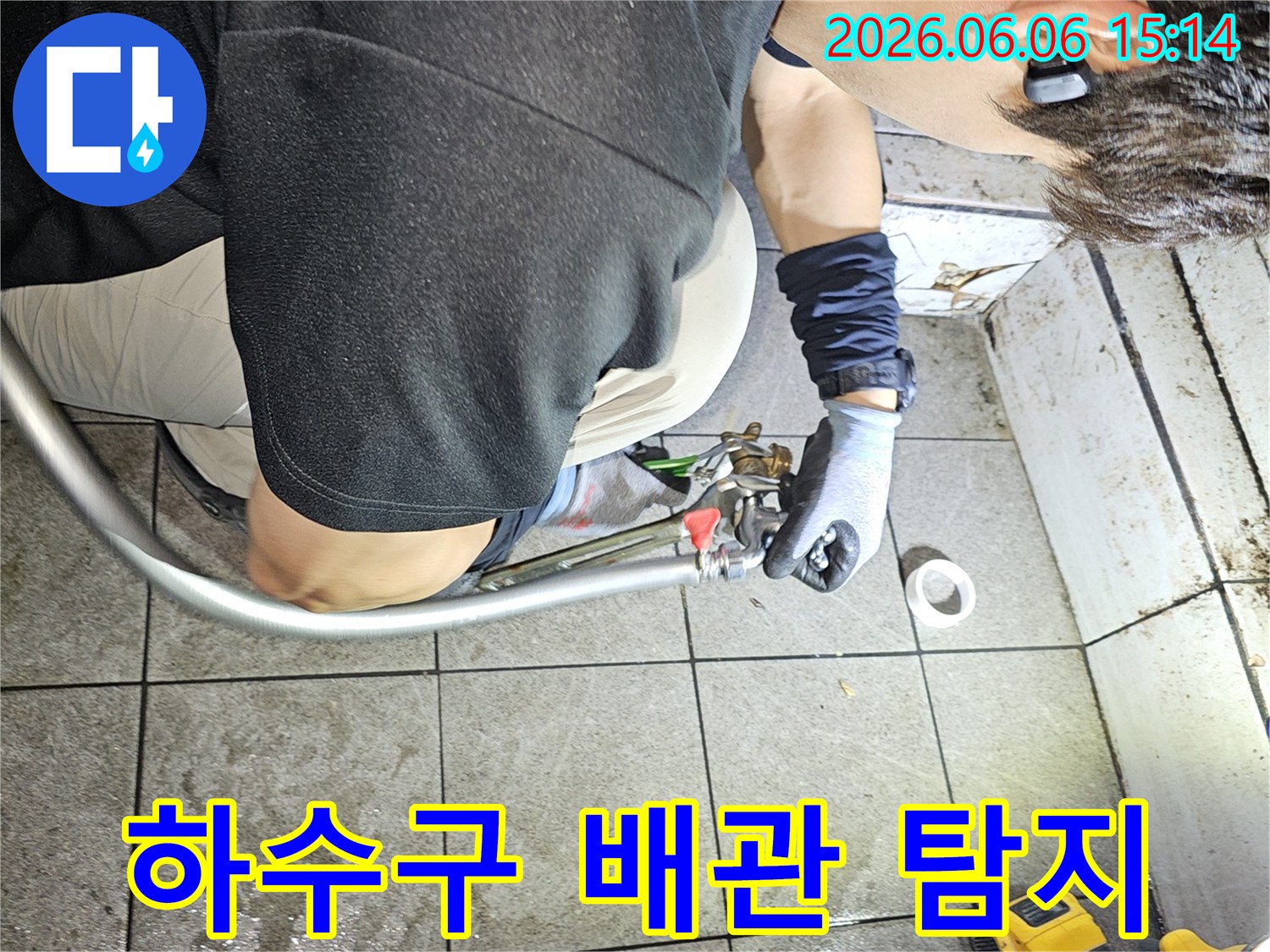 누수 전문가가-하수구 배관의 누수를-탐지하기 위해 장비를 연결하는 모습