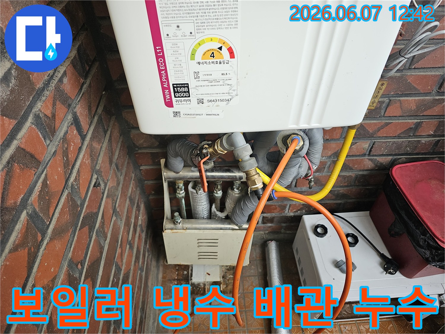 이 이미지는-서울 금천구 독산동의 한 건물에서-가스보일러의-냉수 배관 연결 부위에서-발생한 누수를-엔지니어가-정밀하게 점검하는-모습을 담고 있습니다
