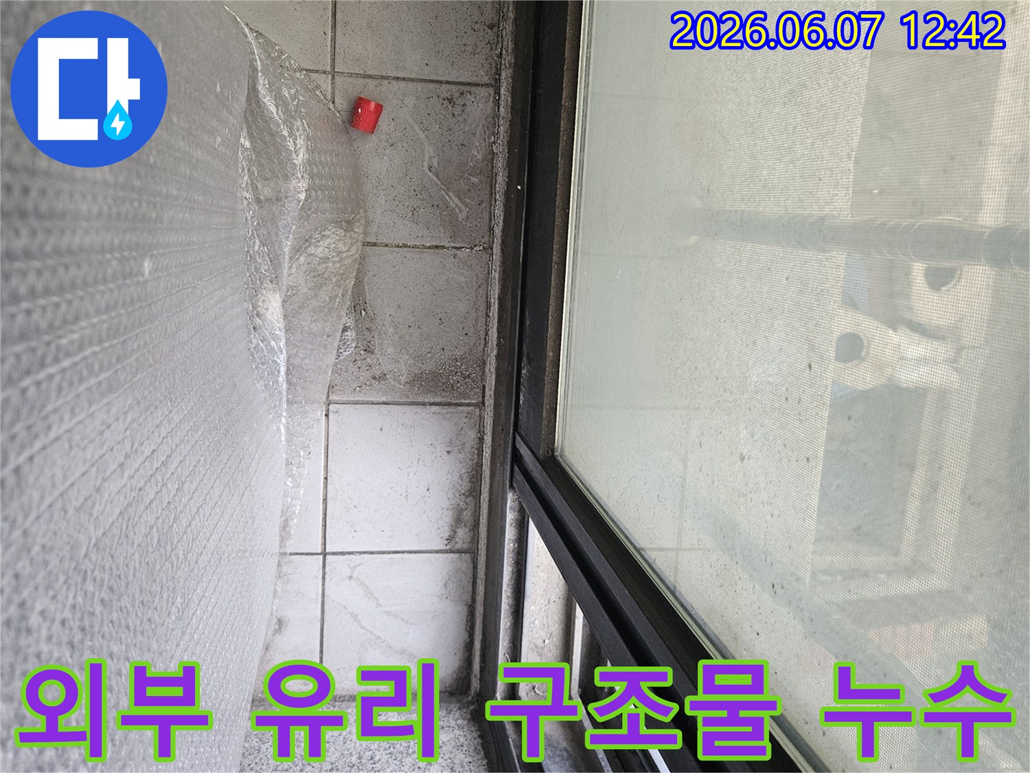 이 이미지는-외부 유리 구조물 하부에서 발생한-누수 문제 해결을 위한 현장 준비 모습입니다