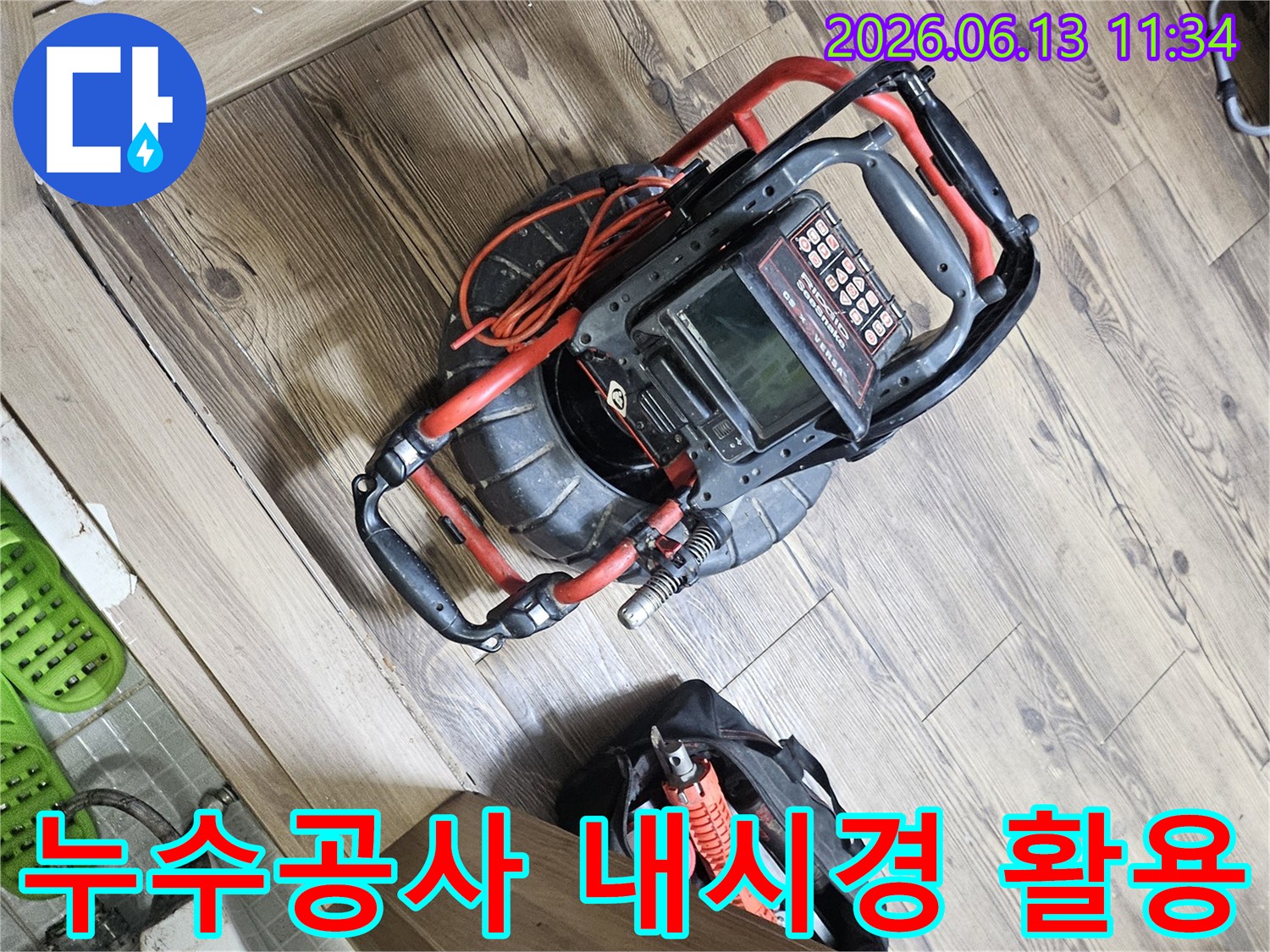 누수공사 효율 증대를 위한-배관 내시경 장비와-필요한 공구들이 바닥에 놓여있는 현장