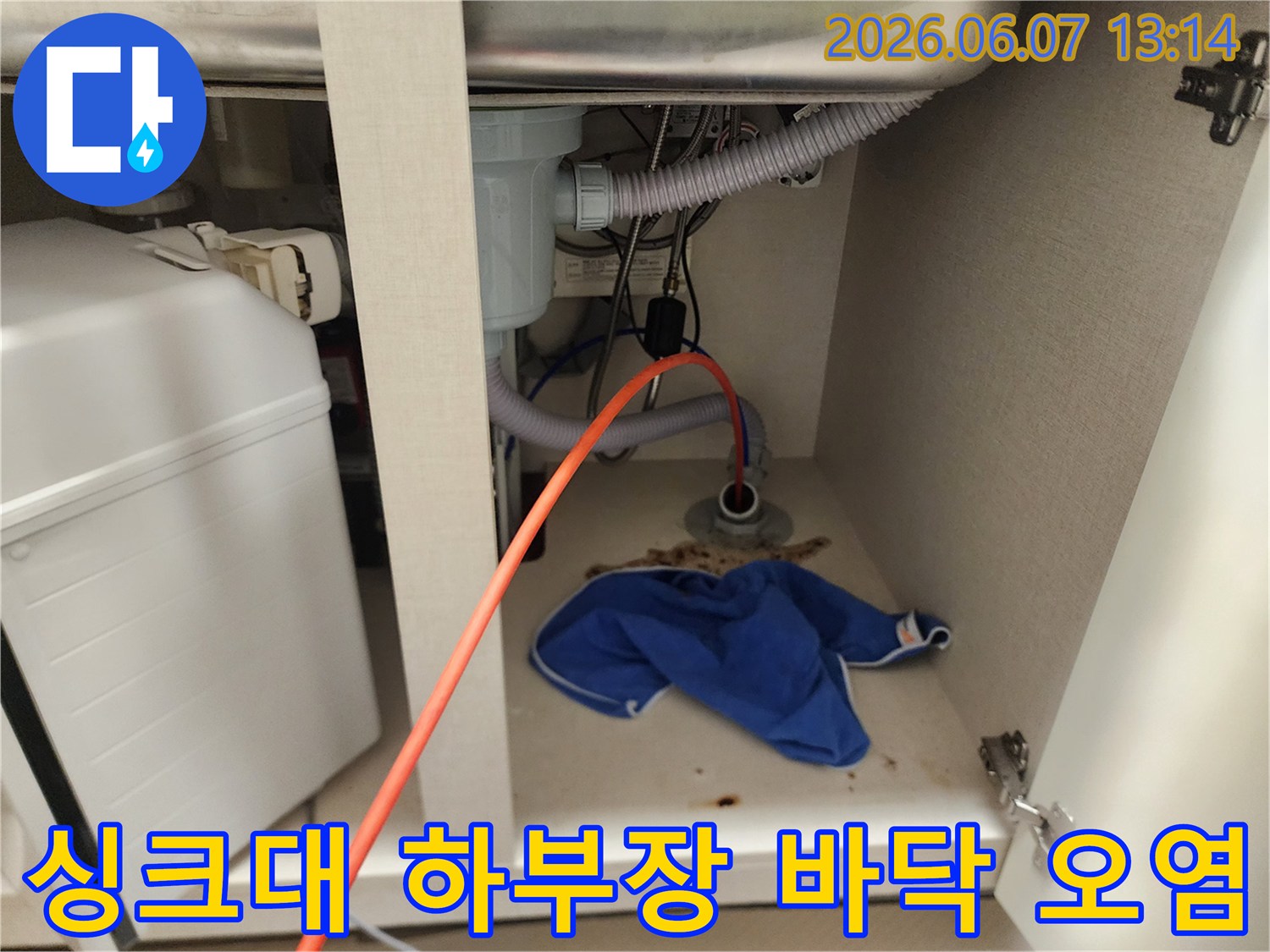 하수구 배관 주위로 역류한 이물질과 젖은 걸레가 있는 싱크대 하부 모습입니다.