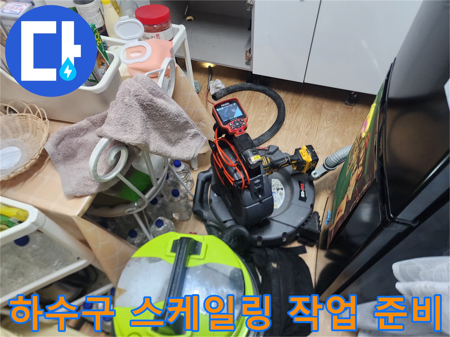 배관 내부 청소를 위해 싱크대 아래에 배치된 전문 장비 세트