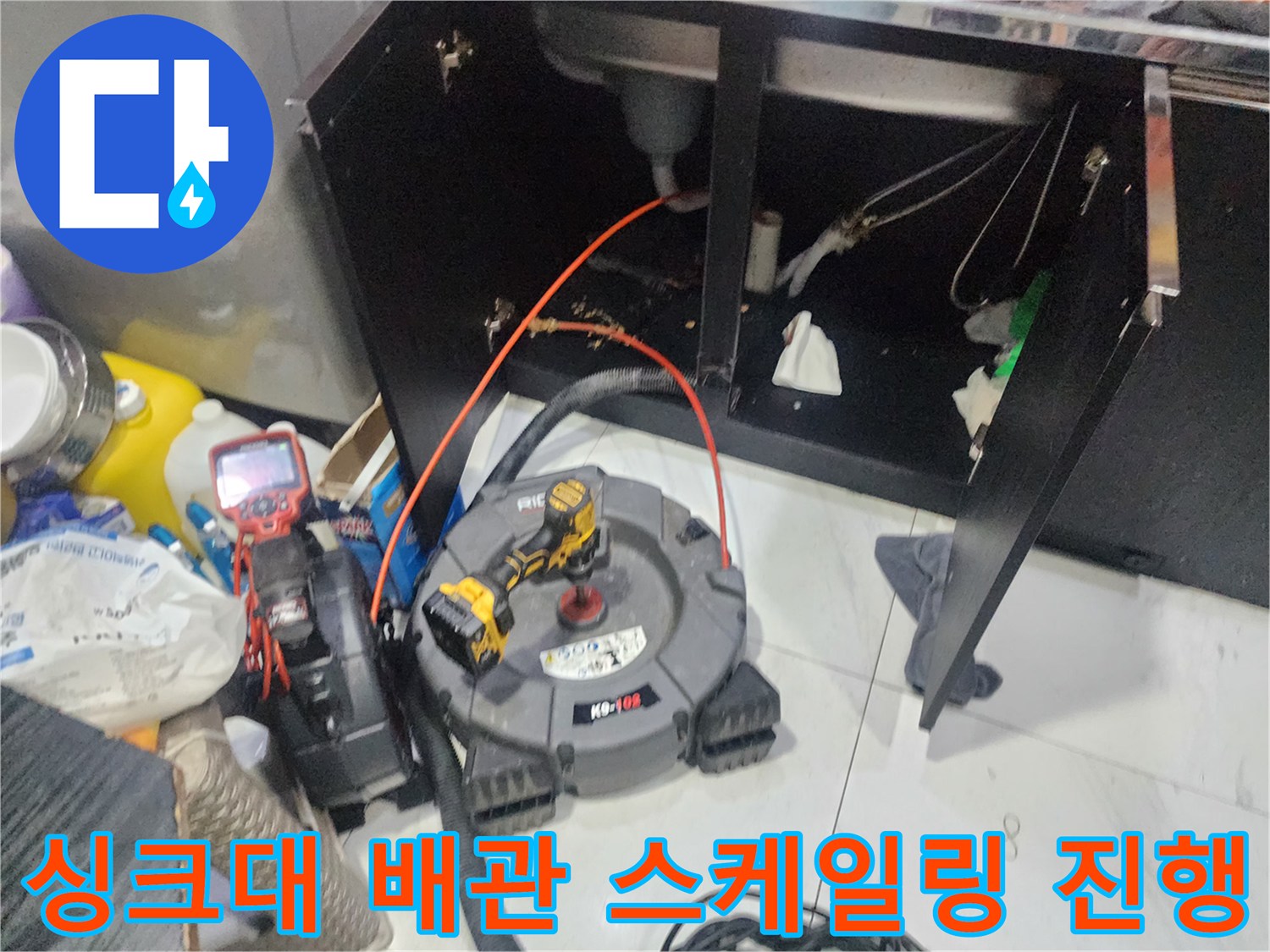 싱크대 하부 배수관을 따라 연결된 작업용 케이블과 장비들