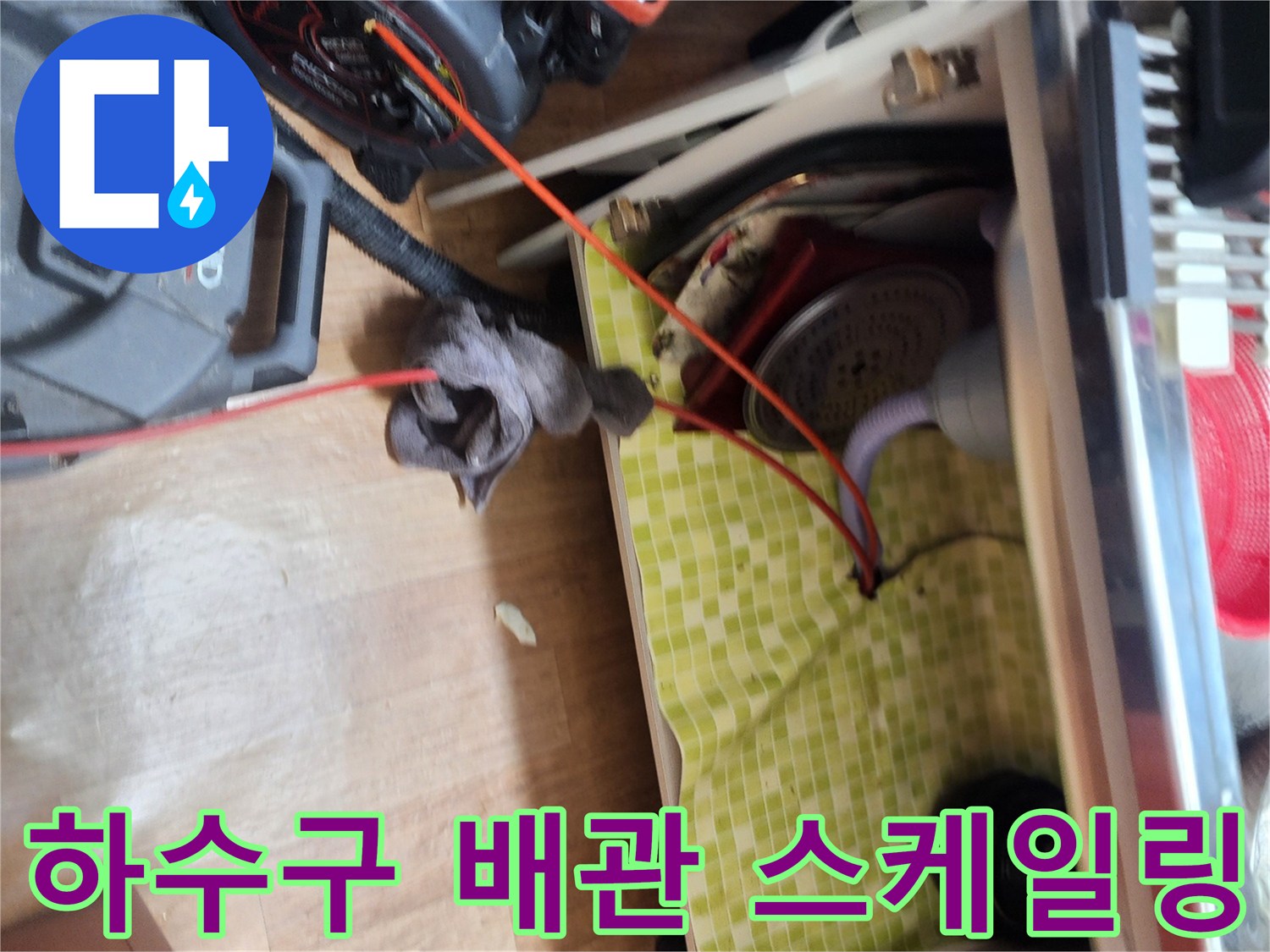 싱크대 하부 배관 내부의 슬러지를 제거하기 위해 전문 장비를 가동하는 모습입니다.