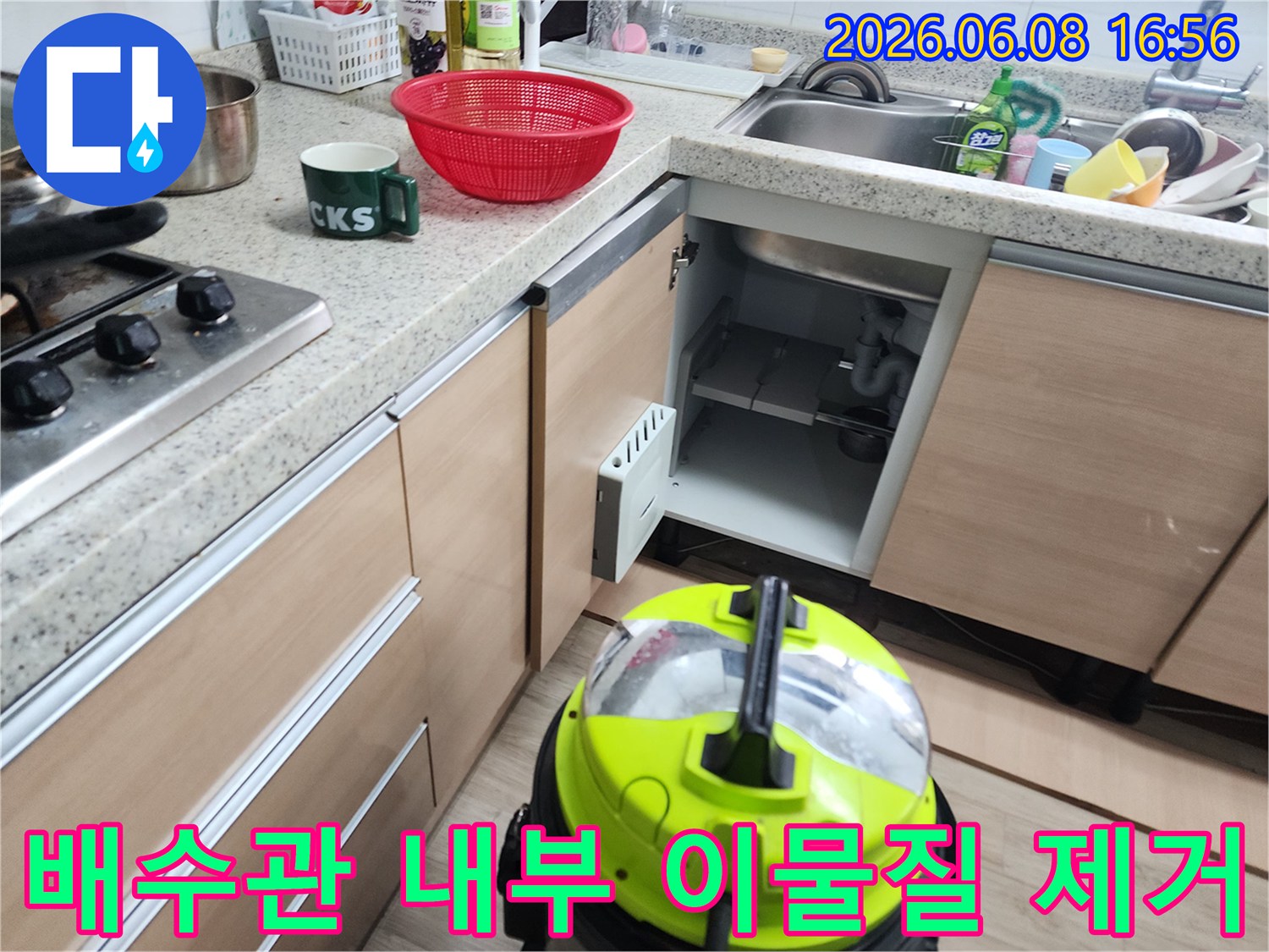 강력한 석션기를 사용하여 배수관 속 오물을 흡입하는 작업 장면입니다.