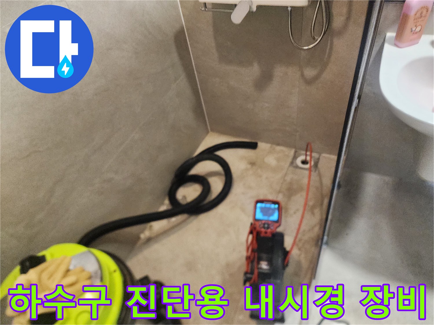 욕실 바닥 타일과 배수구 근처에 놓인 배관 검사용 내시경 모니터