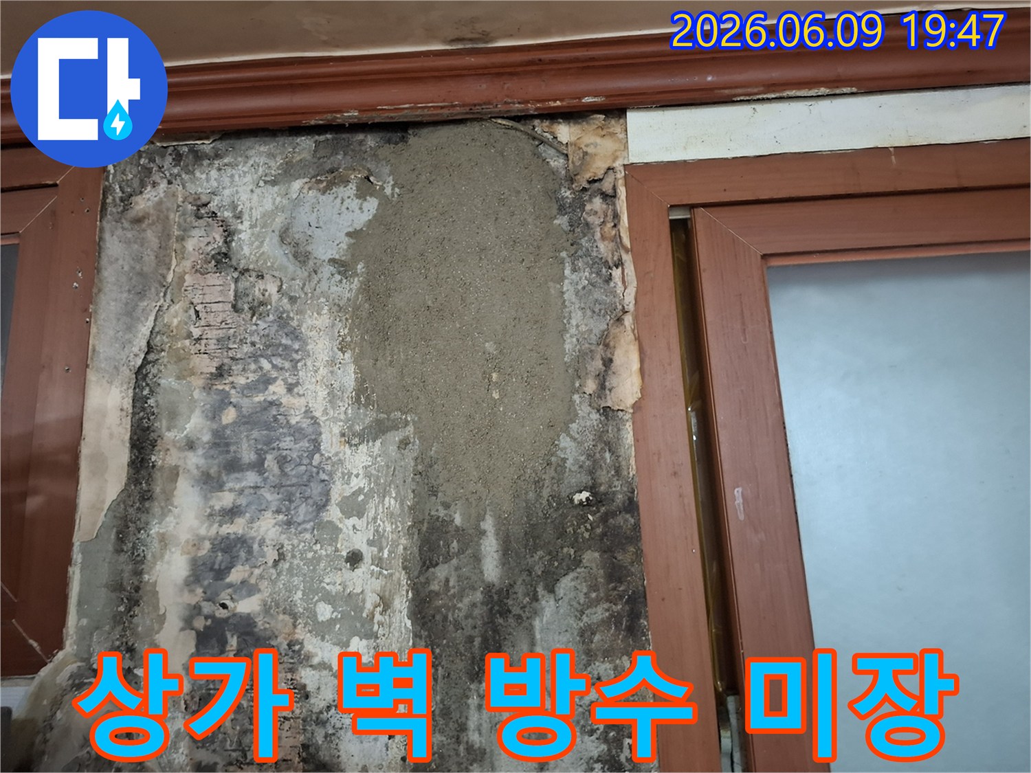 오래된 상가 벽면에 발생한 누수 문제를 해결하기 위해 방수 처리 후 미장으로 깔끔하게 보수한 모습