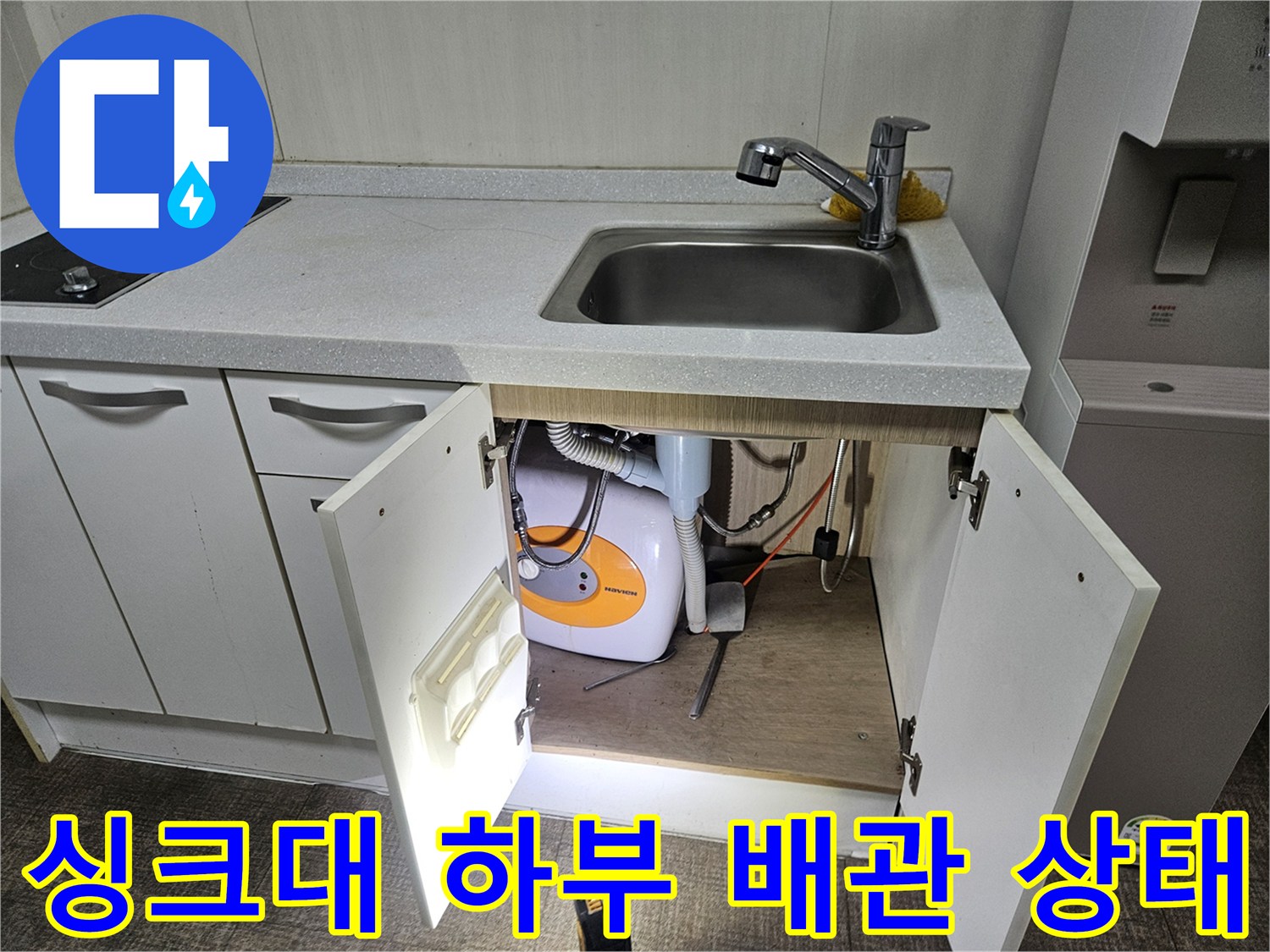 주방 하부장 내부-세탁기 연결 호스와 급수 밸브 점검 중