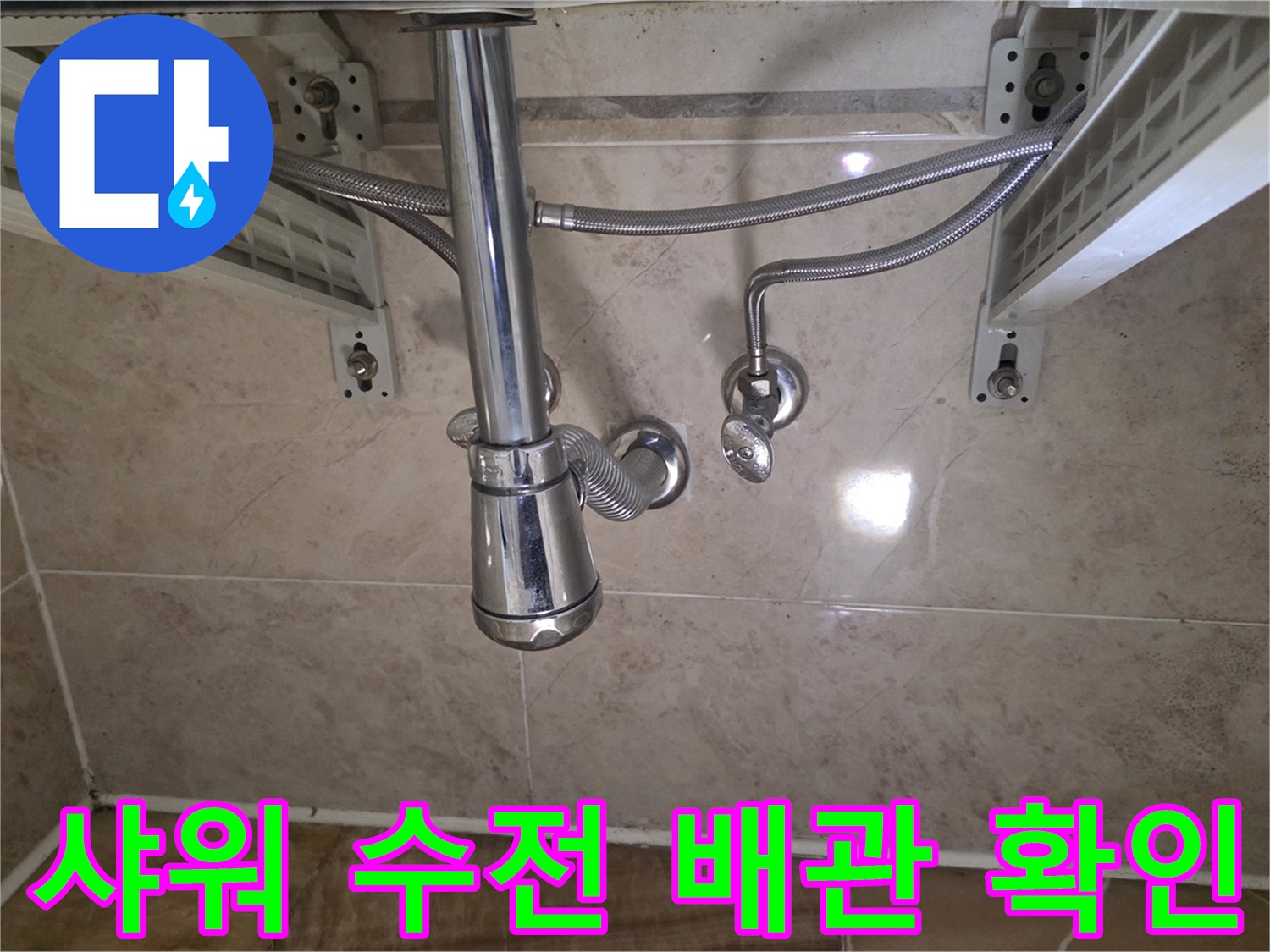 화장실 점검구 내부의 샤워기 수전과 금속재질의 호스 모습