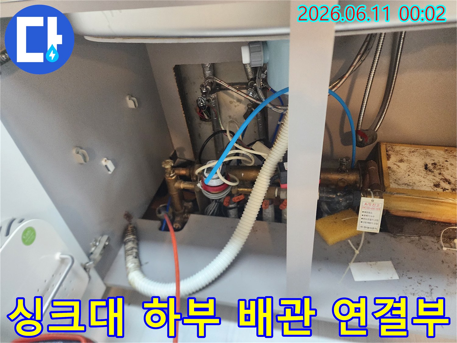 싱크대 아래쪽의 연결 부위와 노후된 배관들을 촬영한 사진입니다.