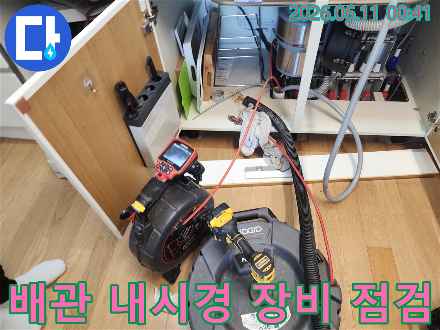 싱크대 하부장 내부에서 배관 상태를 확인하기 위해 설치된 내시경 카메라와 장비들입니다.