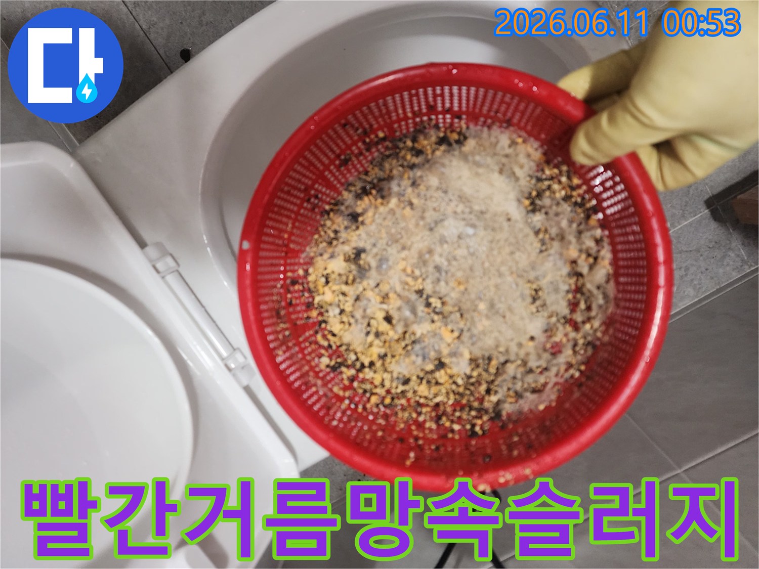 빨간색 거름망에 가득 담겨 있는 배관 내부의 기름 슬러지와 이물질