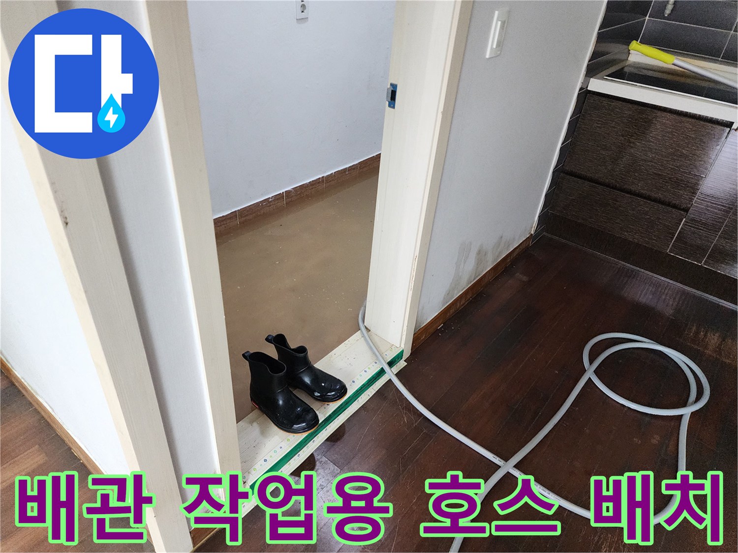 문턱을 가로지르는 고압 세척용 호스와 젖은 바닥
