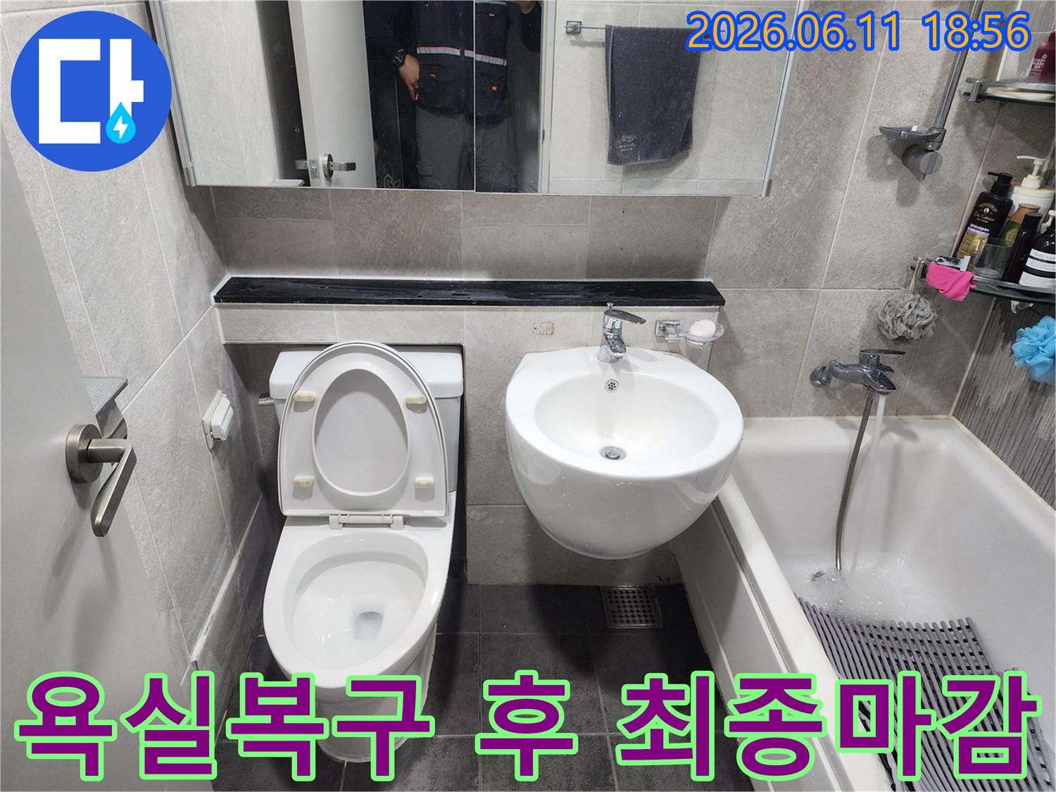 누수-수선-후-타일-마감과-변기-세면대-설치가-완료되어-새로운-모습으로-변모한-욕실의-전경을-보여줍니다