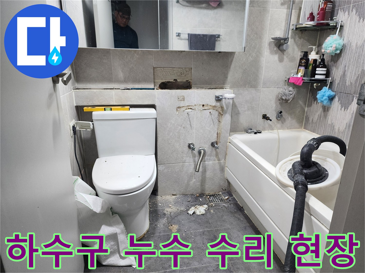이 이미지는-동대문구의 한 화장실에서-하수구 배관의 누수 문제를 해결하기 위해-바닥 타일을 제거하고-손상된 하수구 배관을 수리하는-작업 현장을 보여줍니다