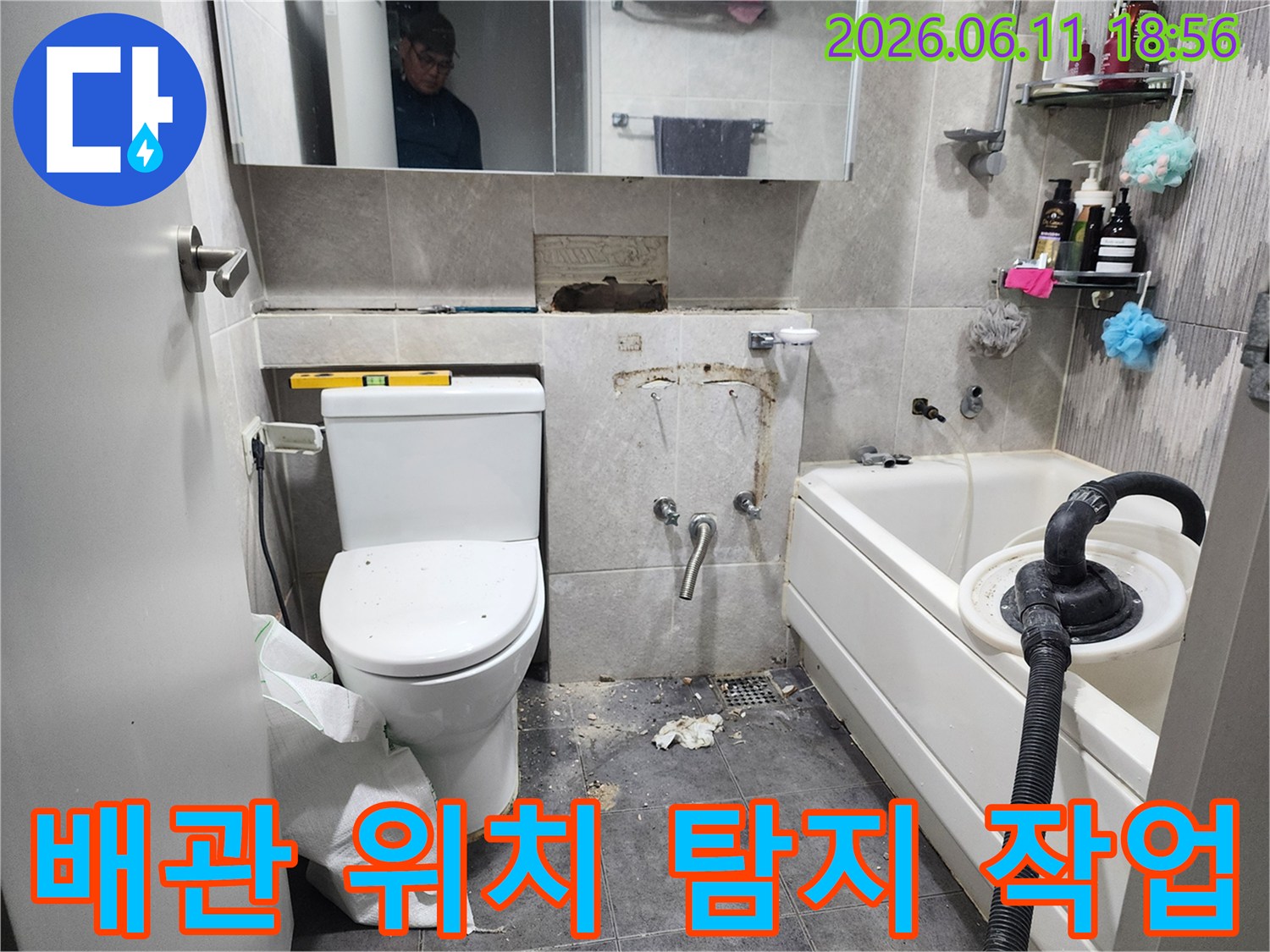 이 이미지는-서울 동대문구의 한 화장실에서-누수 원인인 배관의 정확한 위치를-탐지하기 위해-타일을 제거하고-배관 상태를 점검하는-작업 현장을 보여줍니다