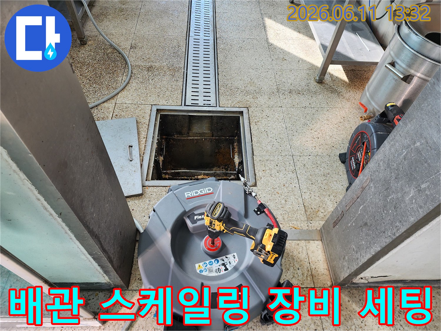 맨홀 입구 옆에 설치된 배관 청소용 리지드 스케일러와 전동 드릴