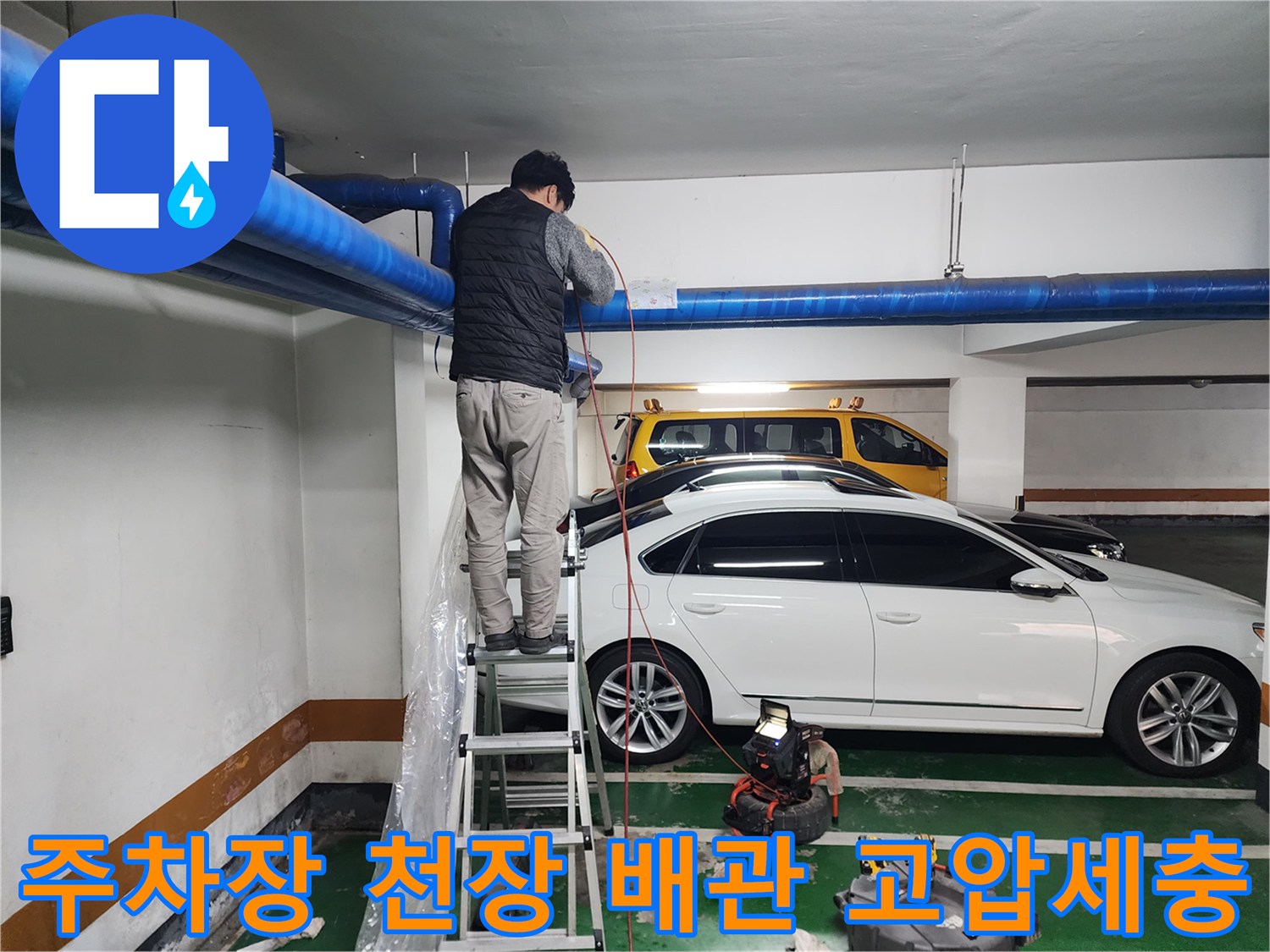 상가 지하주차장-천장 배관 작업 중인 엔지니어의 모습