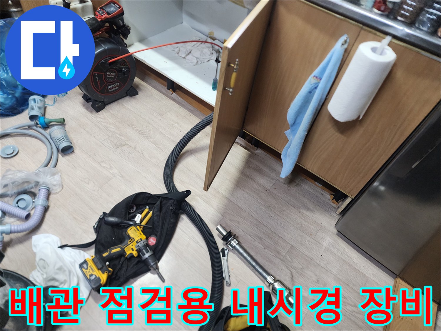 막힌 싱크대 배관을 확인하기 위해 준비된 내시경과 드릴 공구 세트입니다.